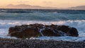 Sea Ã¢â¬â¹Ã¢â¬â¹wave at sunset hitting a long rock on the beach